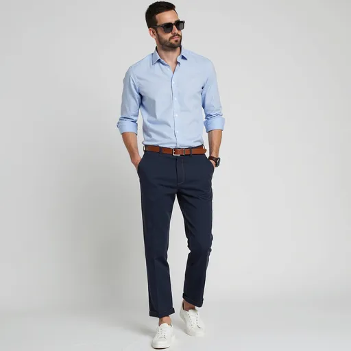 Prompt: The man in the image is wearing a smart-casual outfit that’s both stylish and modern. Here’s a breakdown of the look:

* **Shirt**: Light blue, slim-fit dress shirt, sleeves rolled up for a relaxed yet sharp appearance.
* **Pants**: Navy slim-fit trousers with front seam detailing, tailored to a cropped length.
* **Belt**: Medium brown leather belt adds contrast and ties the look together.
* **Shoes**: Clean white low-top sneakers, perfect for a casual touch to the dressy outfit.
* **Accessories**: Dark sunglasses and a classic watch, enhancing the overall stylish vibe.
* **Grooming**: Well-styled hair and trimmed beard add to the polished look.

This outfit is ideal for semi-formal occasions, date nights, or stylish daytime events. Want a similar look recommendation or tips to replicate it?
