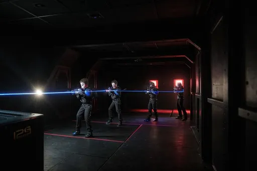 Prompt: Laser tag game of 12 year boys with detail to one with gun