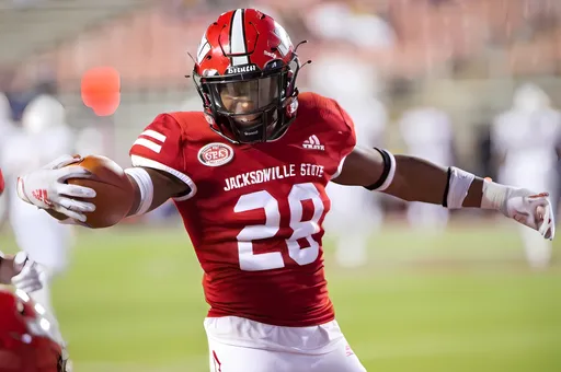 Prompt: Jacksonville State Gamecocks football in modern video game with cardinal red jerseys and helmets.