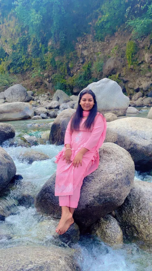 Prompt: a girl sitting on rock in water 