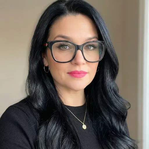 Prompt: Ultra-realistic portrait edit of the same woman, preserving her facial features and expression, but removing the fine lines around her mouth, keep the skin tone, and black gucci glasses.  Slim out her jawline slightly.  Make her makeup more defined with a brighter pink lipstick and longer darker eyelashes, smooth out her skin. Transform her hair to deep jet-black, smooth, glossy, and wavy in texture, noticeably longer with a sleek, healthy shine and soft volume. Dress her in a simple, fitted black sweater with an elegant, minimal look. Add subtle gold jewelry only: small gold hoop earrings and a delicate gold necklace.

Instagram profile photo style: tight head-and-shoulders crop, centered composition, 1:1 aspect ratio. Clean, softly blurred neutral background. Natural window lighting with gentle contrast, flattering shadows, and professional portrait clarity. Sharp focus on eyes, realistic skin texture, no over-smoothing. Polished, confident, modern aesthetic.