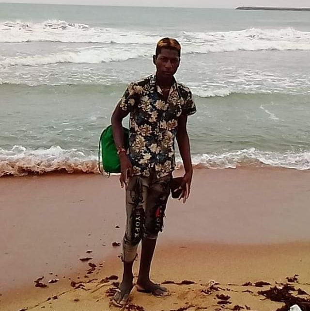 Prompt: ALi Boubacar se rend à Cotonou, la capitale du Bénin, pour la première fois en prenant une photo sur la plage