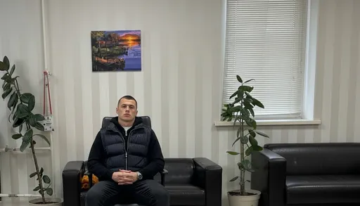 Prompt: замени человека на стуле на человека со второго фото