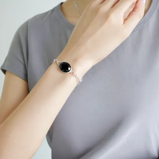 Prompt: <mymodel>Silver bracelet with black gem