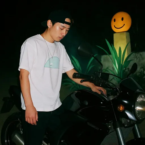 Prompt: Under the dim glow of outdoor lighting, a person stands next to a sleek black motorcycle, their attention focused on the bike's controls. Dressed in a casual white t-shirt adorned with a subtle design and black pants, they exude a relaxed vibe, complemented by a backward cap. The background features a whimsical decoration of a smiling face and plants, adding a playful contrast to the scene. The nighttime setting enhances the glistening details of the motorcycle while creating a cozy, intimate atmosphere. There’s a sense of curiosity and exploration as the individual interacts with the bike, embodying a narrative of adventure and personal expression.