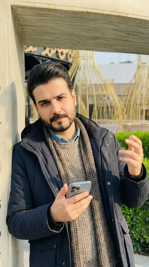 Prompt: غير الاضاءه الى مشمسه من جهة اليمين وحركة اليدين عفويه  وبيدي موبايل وانظر للكاميرا بميلان بسيط