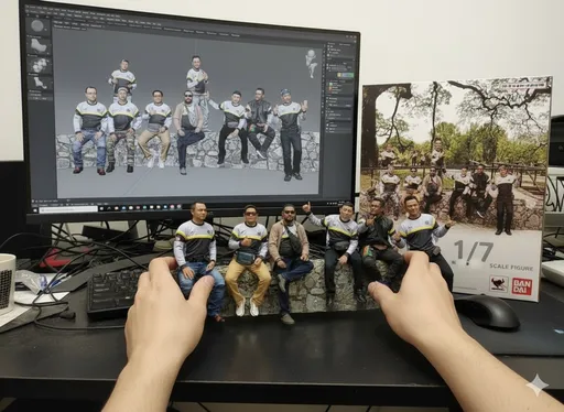 Prompt: Two hands gently pick up the figure in the frame and rotate it slightly for inspection. The model on the computer screen and the model printed on the packaging box remain stationary, while all other background elements stay unchanged.