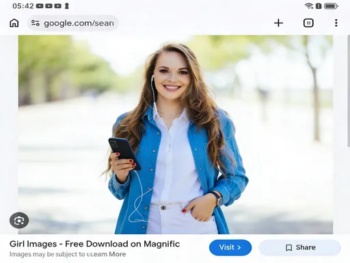 Prompt: This is a photograph of a young woman standing outdoors in a bright, sunlit area with a blurred background of green trees and a light-colored pathway. She has long, wavy brown hair and is smiling warmly at the camera. She is wearing a bright blue, button-up denim jacket over a white shirt, paired with white high-waisted pants. Her right hand is in her pocket while her left hand holds a smartphone, from which white earphones dangle. The phone has a black case. The woman's skin is fair, and she has light makeup, including pink lipstick. The image has a soft focus effect, particularly in the background, which emphasizes the subject. The top of the image shows a white interface with a timestamp "05:42" and various app icons, indicating it is displayed within a messaging app. The text at the bottom reads "Girl Images - Free Download on Magnific (formerly Freepik)" with a "Visit 2" button and options to "Share" or "Save". The overall style is casual and modern, with a focus on the subject's relaxed, friendly demeanor and the bright, cheerful color of her jacket.