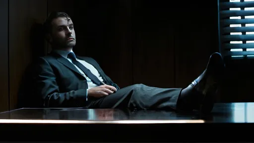 Prompt: Man in suit sitting in a very dark study room with his legs on the table.