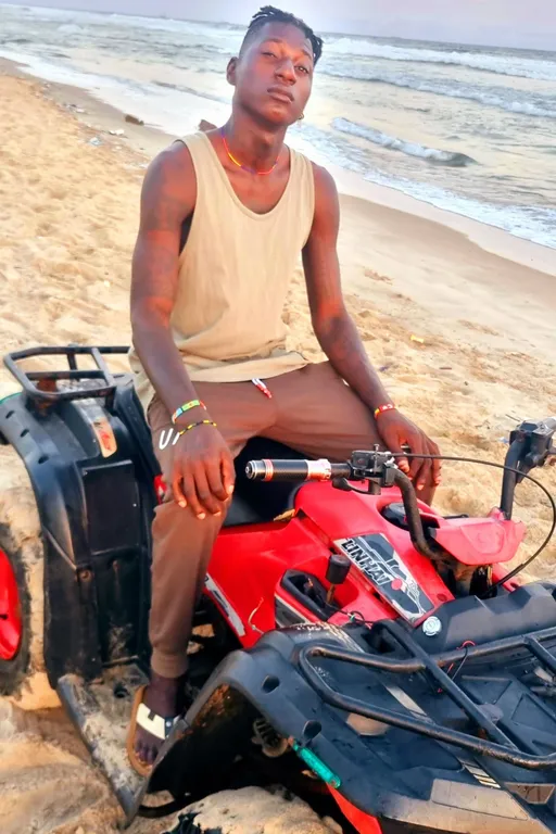 Prompt: ALi Boubacar enjoyed a thrilling ride on a quad bike along the beach