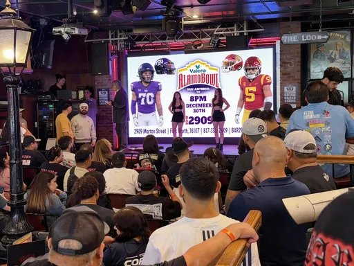 Prompt: Add the alamo bowl poster to the screen in the picture 