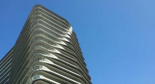 Prompt: add clear blue sky to the building background on a sunny day in malaysia around noon
