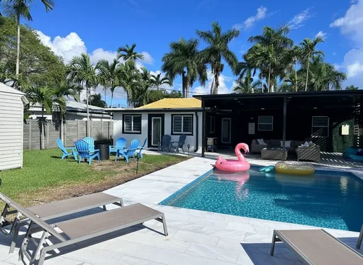 Prompt: Enhance this backyard pool photo for an Airbnb listing. Add a pink flamingo float in the pool. Improve color contrast and lighting for a glossy magazine-style look. Remove any dull or shadowy areas, fix grass texture, and make the water sparkle. Keep it realistic but photo-ready., the darker side of the house enhance it and show the lshape sofa 