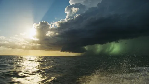 Prompt: Time-lapse style shot of Gulf of Mexico horizon, blue sky rapidly darkening with storm clouds gathering and rolling in, sun being swallowed by ominous black thunderheads, calm water surface becoming choppy, light transitioning from golden to gray to threatening green-gray, wind visible in spray, sense of impending doom, dramatic weather transformation, cinematic disaster film aesthetic, 4K
