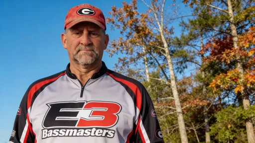 Prompt: @K5c5dbnr11NN6IqlbxE7 is wearing a bass fishing jersey that has E3 Bassmasters on it.  The photo is a medium shot.  @K5c5dbnr11NN6IqlbxE7 has a look of confidence and he is wearing a faded red hat with the university of Georgia logo on it