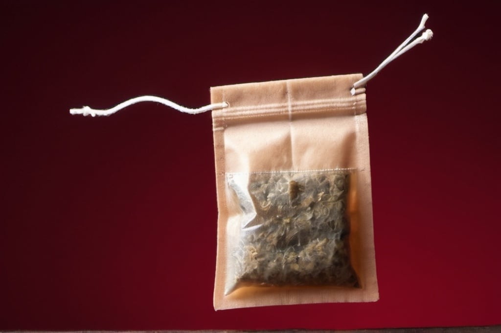 Prompt: Tea bag with dark red background 