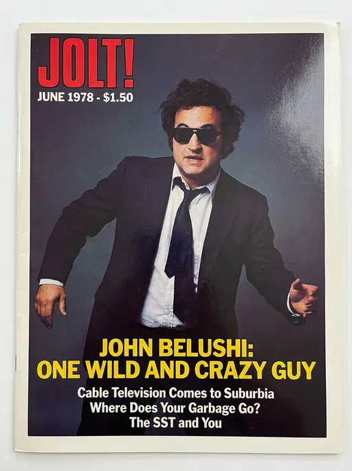 Prompt: JOLT! cover for June 1978 with John Belushi cover photograph by Annie Leibovitz, article headline: John Belushi: One Wild and Crazy Guy
Secondary articles: 
Cable Television Comes to Suburbia,
Where Does Your Garbage Go?,
The SST and You



Glossy large format prestige magazine, colourful, 