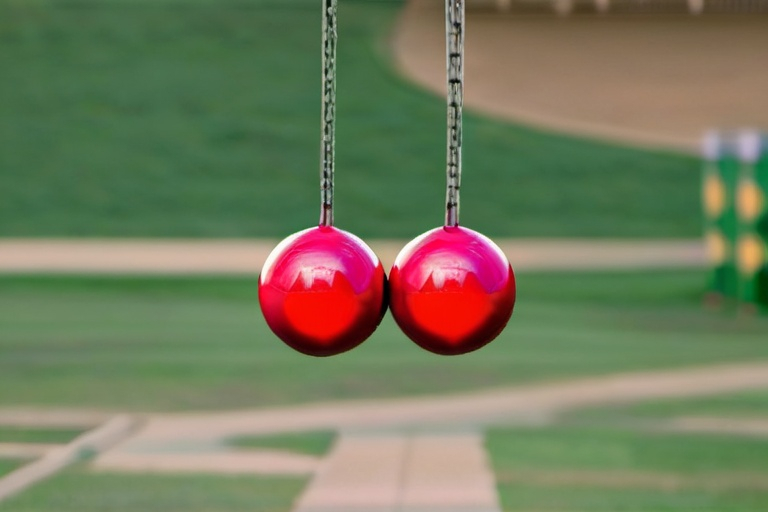 Prompt: Two pendulous sagging balls swinging from below 