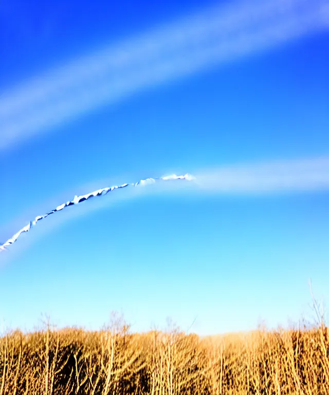 Image similar to thin cloud trails loops in cursive on clear blue sky, skywriting