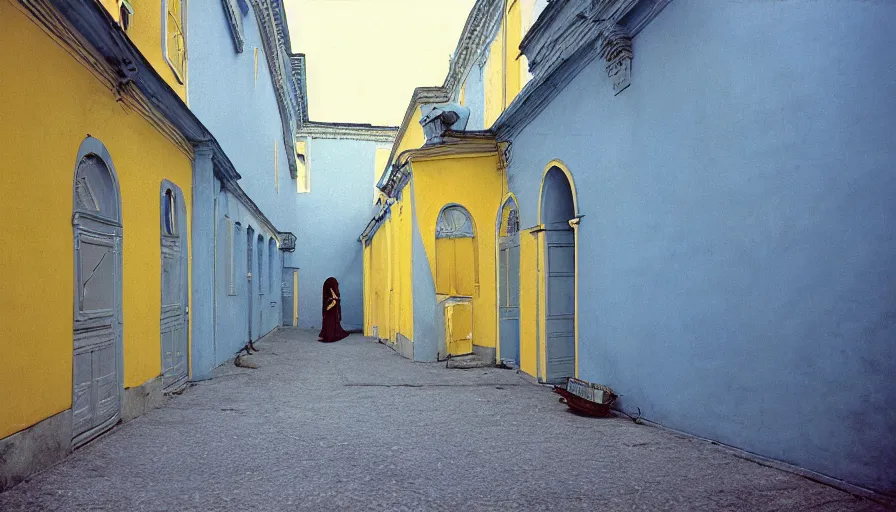 Prompt: 1 9 7 0 s movie by tarkovsky still of old socrates in blue drapery in a yellow neoclassical street with collums, cinestill 8 0 0 t 3 5 mm, high quality, heavy grain, high detail, panoramic, ultra wide lens, cinematic composition, dramatic light, anamorphic, piranesi style, etienne - louis boullee style