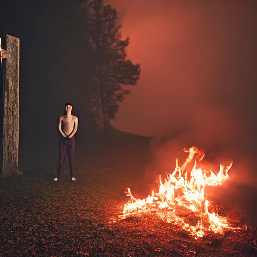 Image similar to robert lewandowski in front of a burning christian cross, night, forest, dark, black