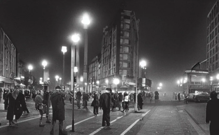 Image similar to 1990s movie still of a german street with a large crowd of philosophers, with stalinist style highrise, cinestill 800t 35mm black and white, heavy grainy picture, very detailed, high quality, 4k panoramic, hd criterion streetlight at night, foggy