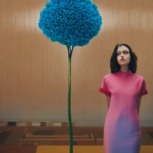 Image similar to giant flower head, frontal, girl standing in mid century hotel, surreal, symmetry, bright colors, cinematic, wes anderson