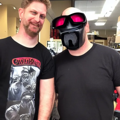 Image similar to ethan van sciver hanging out with a short stocky guy who wears a red ski mask over his face with black ski goggles, cargo shorts and a plain black t - shirt that says cash grab