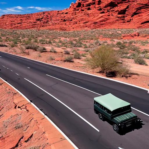 Prompt: a vintage land rover defender drives along a 2 lane road in the valley of fire, drone photo