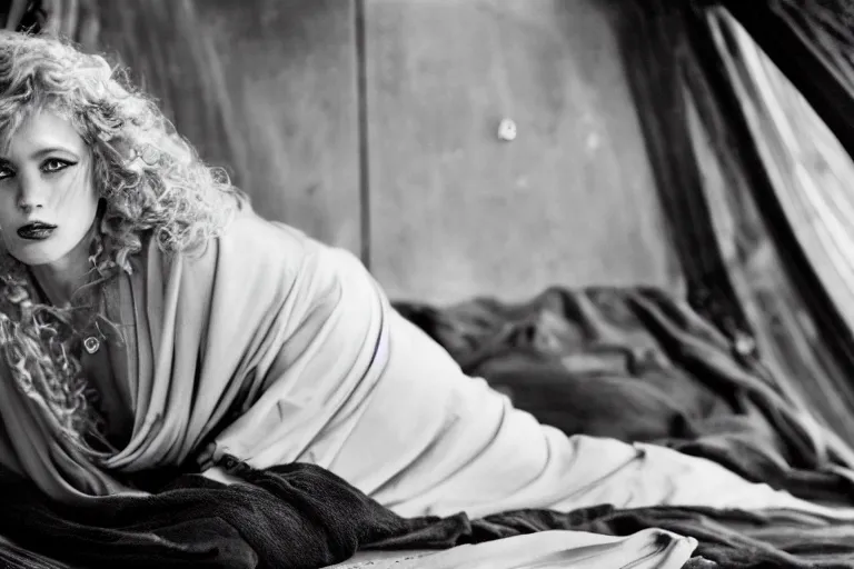 Image similar to a blonde woman in a black robe lying down on the deck of a ship, a beautiful english woman with a long face narrow nose pale skin blue eyes red lips and wild messy tangles of curly white blonde hair, high resolution film still wearing a black robe and skull necklace, sandy, a journey to the west