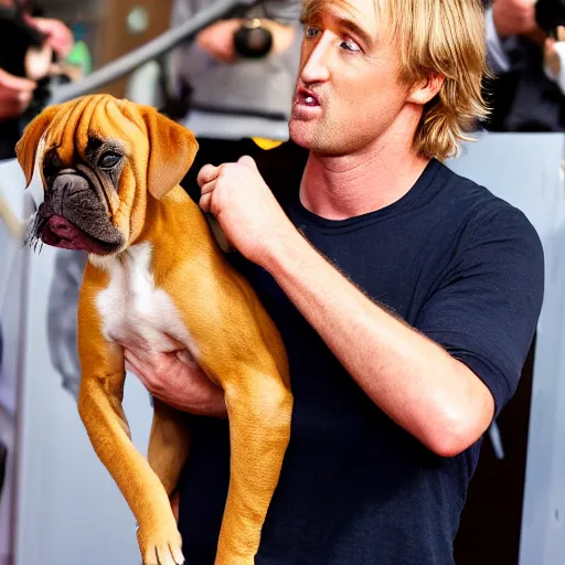 Image similar to 50mm photo, Owen Wilson saying wow holding a boxer puppy