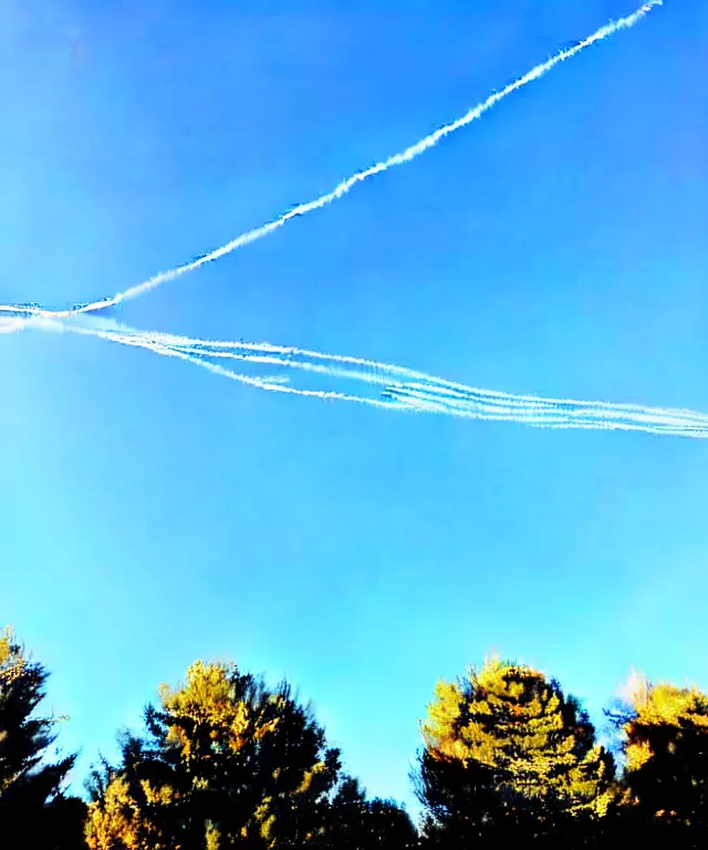 Image similar to thin cloud trails in cursive on clear blue sky