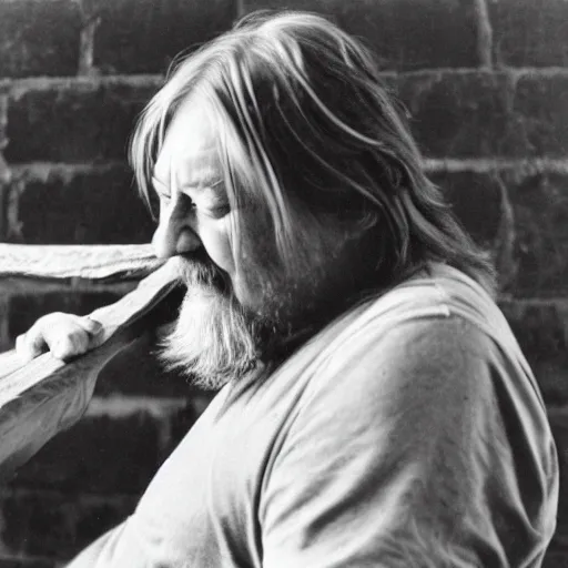 Image similar to robert wyatt gnawing on a long plank of wood, black and white photograph