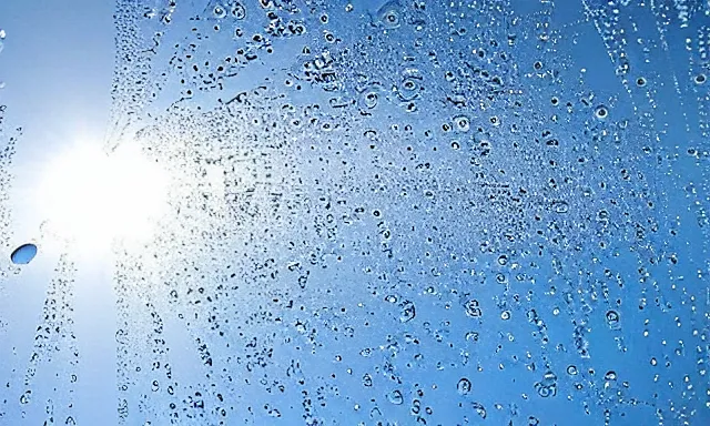 Image similar to beautiful picture of a sunny blue sky with a magical vertical cylindrical tunnel of big upside-down raindrops floating quietly