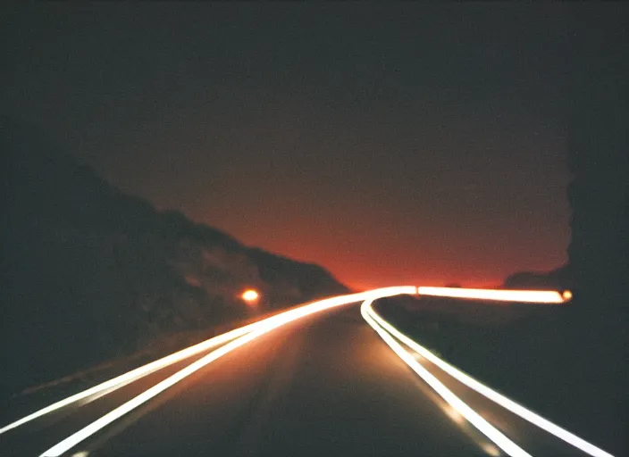 Prompt: pov headlights of a car illuminate a strange dark canyon road, it's the dead of night, in a distance the bright city lights glow, cinematic, cinestill