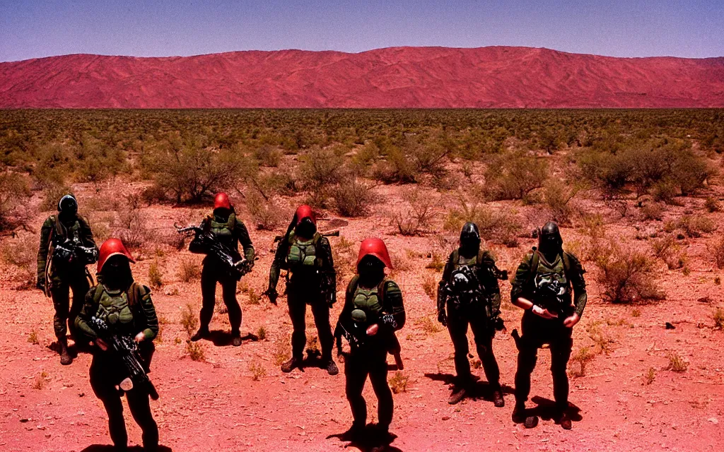 Image similar to a team of five people in dark green tactical gear like death stranding and masks, red mesas behind them, look at a desert oasis in the distance. They 're afraid. dusty, red, mid day, heat shimmering, 35mm film