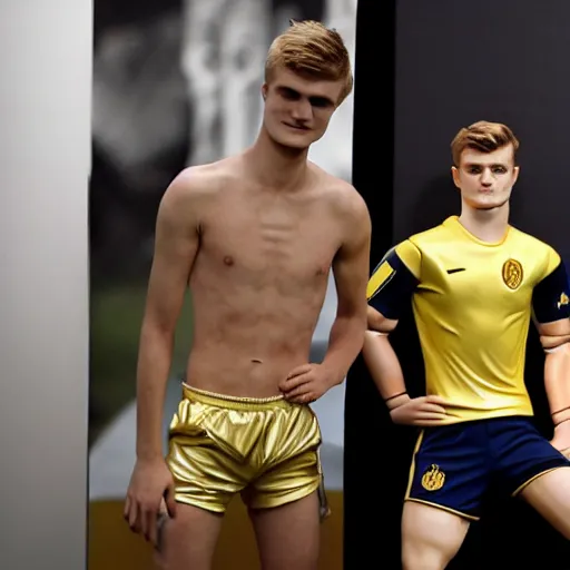 Image similar to a realistic detailed photo of a guy who is an attractive humanoid who is half robot and half humanoid, who is a male android, soccer players martin ødegaard & timo werner, shiny skin, posing like a statue, blank stare, in a factory, on display, showing off his muscles, gold soccer shorts, side view, looking at each other mindlessly