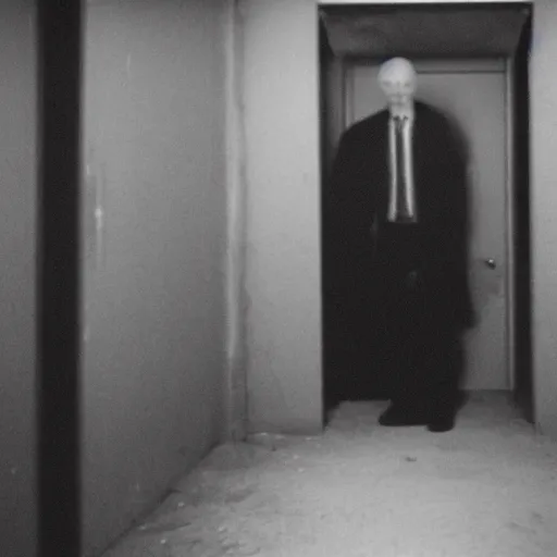 Prompt: a expired flash photo of creepy man with an unnatural posture standing in a vantablack russian basement from the horror movie rec, out of focus, uncanny valley, shaky camera, it is deformed and is staring at the camera from the end of a dark liminal hallway. caught on vhs, film grain, national geographic award winning photography,