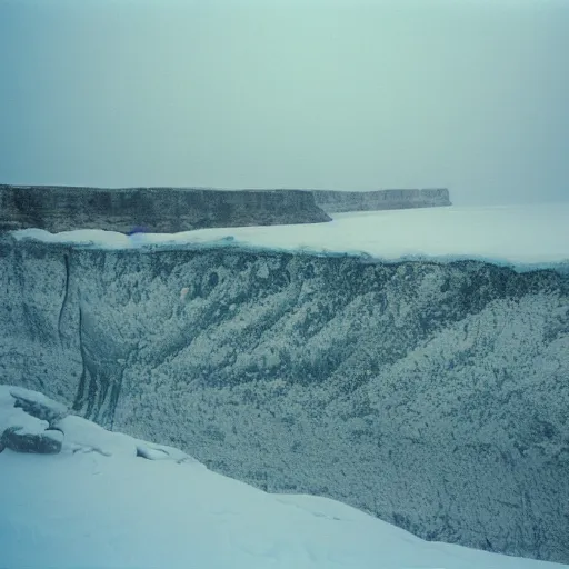 Image similar to photo of green river, wyoming cliffs covered in ice and snow, during a snowstorm. a old man in a trench coat and a cane appears as a hazy silhouette in the distance, looking back over his shoulder. cold color temperature. blue hour morning light, snow storm. hazy atmosphere. humidity haze. kodak ektachrome, greenish expired film, award winning, low contrast.