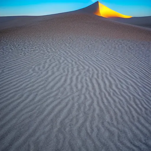 Image similar to a large sand dune with a large obelisk hovering in the middle of the sand dune. clear sky, grainy.