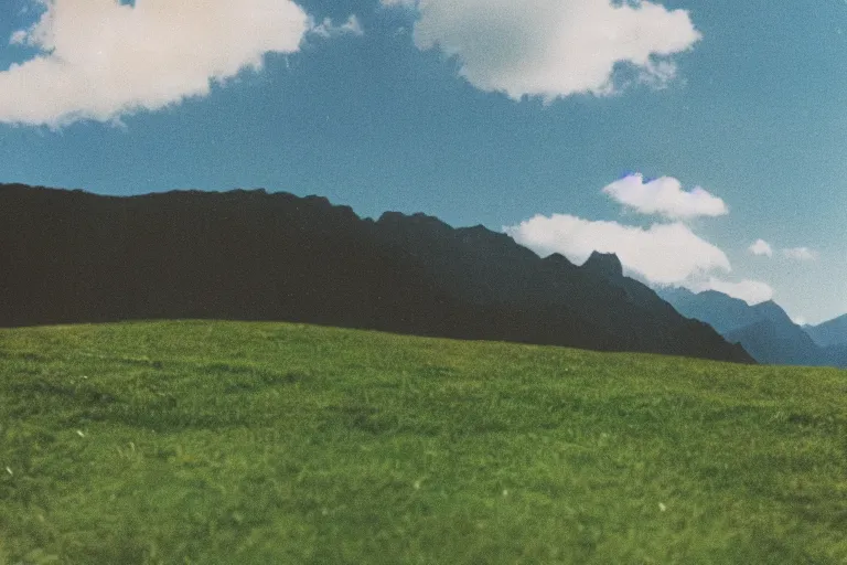 Prompt: film color photography, green lawn, small mirror reflected clouds, no focus, mountains in distance, 35mm