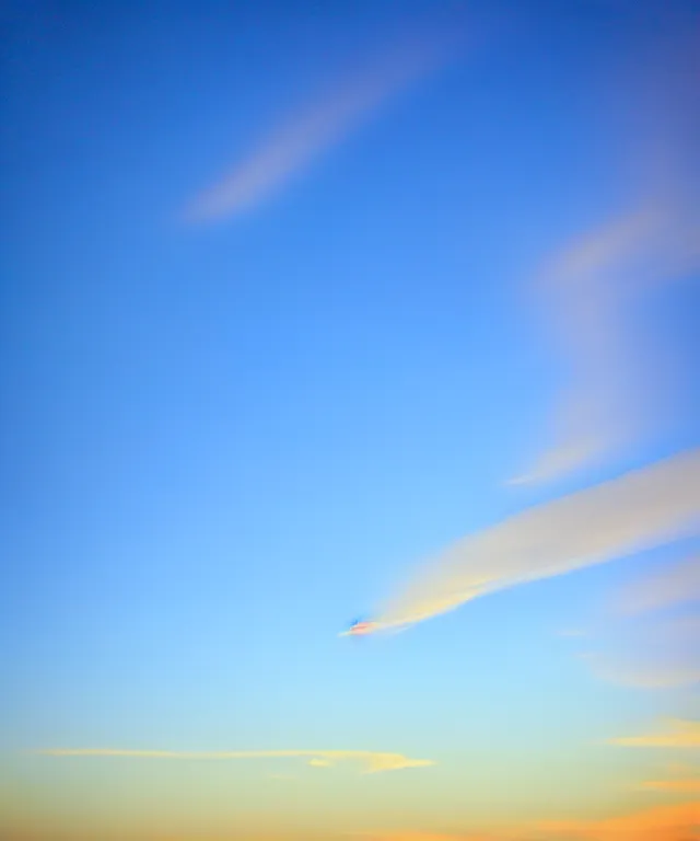 Image similar to thin cloud streaks in cursive on clear blue sky sunset