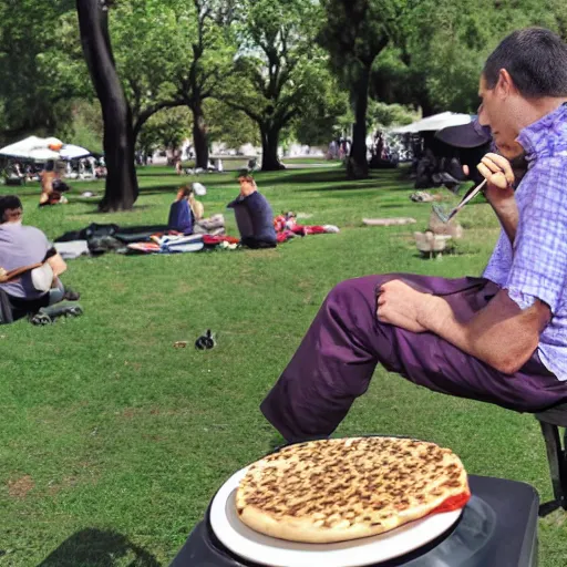 Image similar to in the park, a disc jockey playing music from turntables and eating a falafel pita sandwich