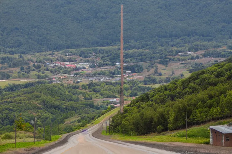 Image similar to looking down road, buildings on both sides. hills background with radio tower on top. telephoto lens compression.