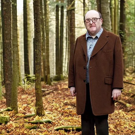 Image similar to Alex Norton wearing a brown overcoat and brown suit standing in a forest.