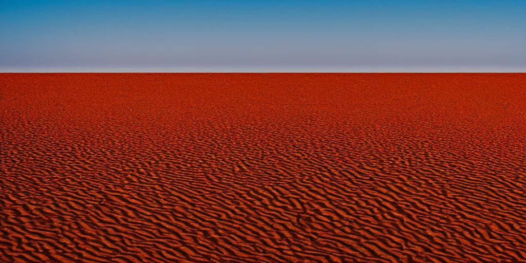 Prompt: Color photograph of orange desert meeting a sky-blue ocean, in the style of Ansel Adams, landscape photography