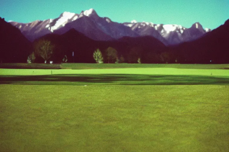 Prompt: film color photography, long view of green lawn with mirror that reflected red, no focus, mountains in distance, 35mm