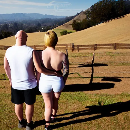 Image similar to portrait of a young chunky bald white male tattoos and his young white female brown hair wife with tattoos. male is wearing a white t - shirt, tan shorts, white long socks. female is has long brown hair and a lot of tattoos. photo taken from behind them overlooking the field with a goat pen. rolling hills in the background of california and a partly cloudy sky