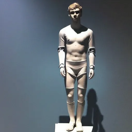 Image similar to “ a realistic detailed photo of a guy who is an attractive humanoid who is half robot and half humanoid, who is a male android, soccer player antoine griezmann, shiny skin, posing like a statue, blank stare, at the museum, on display ”