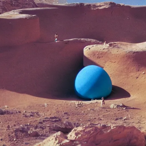 Prompt: a Non-Euclidean orb-like clay house sitting in the desert, vintage photo, beautiful cinematography, blue sky, film grain